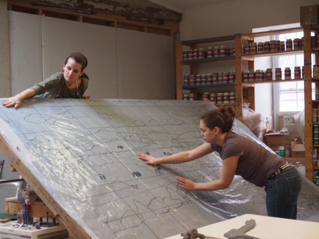 Gigi and Rachel smoothing the plastic pattern over the clay.