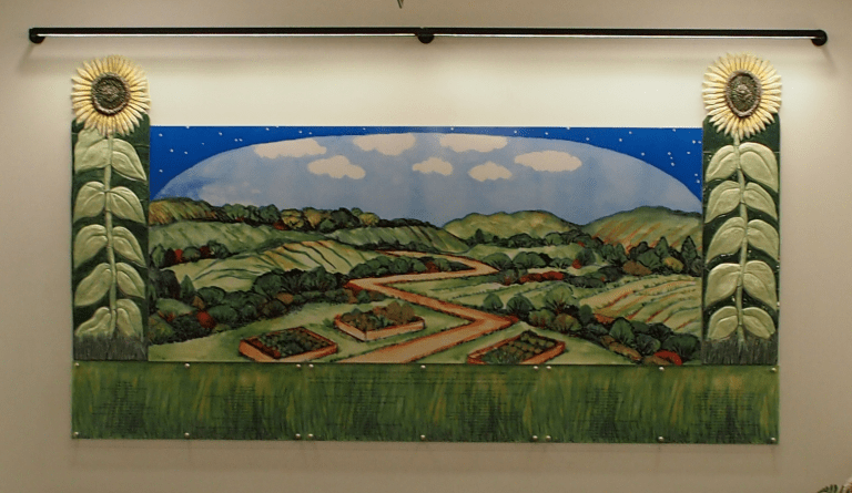 A colorful mural depicting a rural landscape with rolling hills, a winding road, and gardens, framed by large stylized sunflowers on either side against a blue sky.